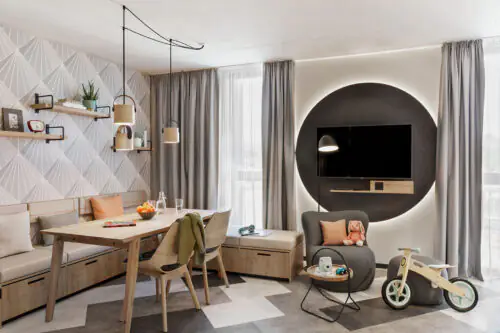 Familienfreundliches Studio mit Esstisch, Sessel, TV und dekorativen Elementen – hell und großzügig.