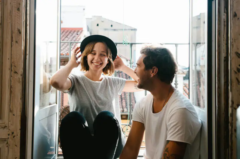 Young couple relaxing together on an apartment balcony during a city stay.