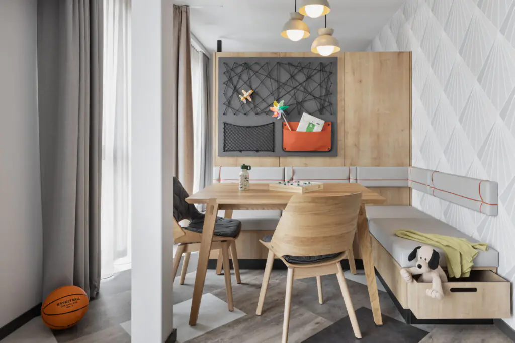 Dining area with wooden table, chairs, bench and decorative wall design in the room.