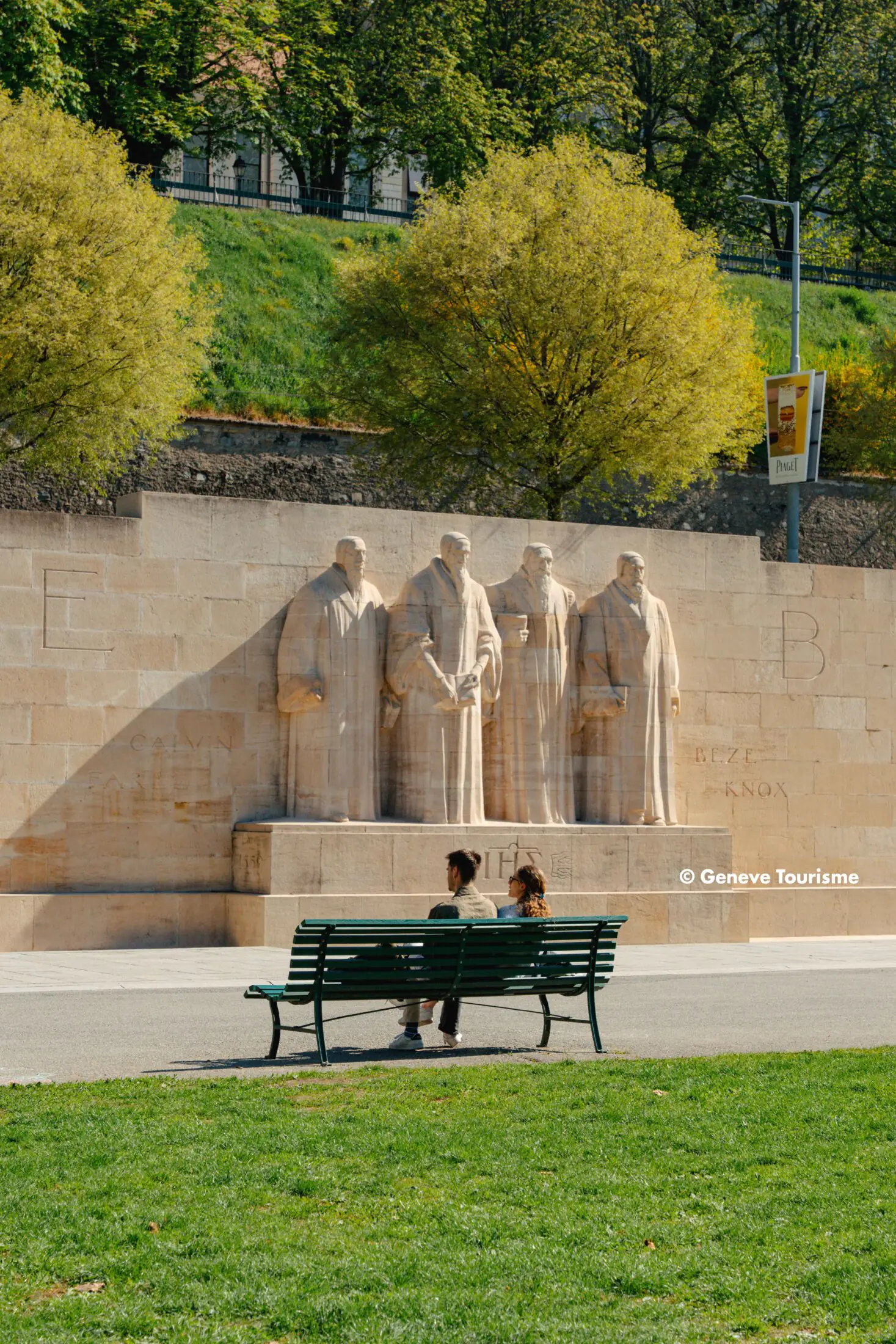 Reformationsdenkmal im Parc des Bastions in Genf mit Sitzbank im Vordergrund.