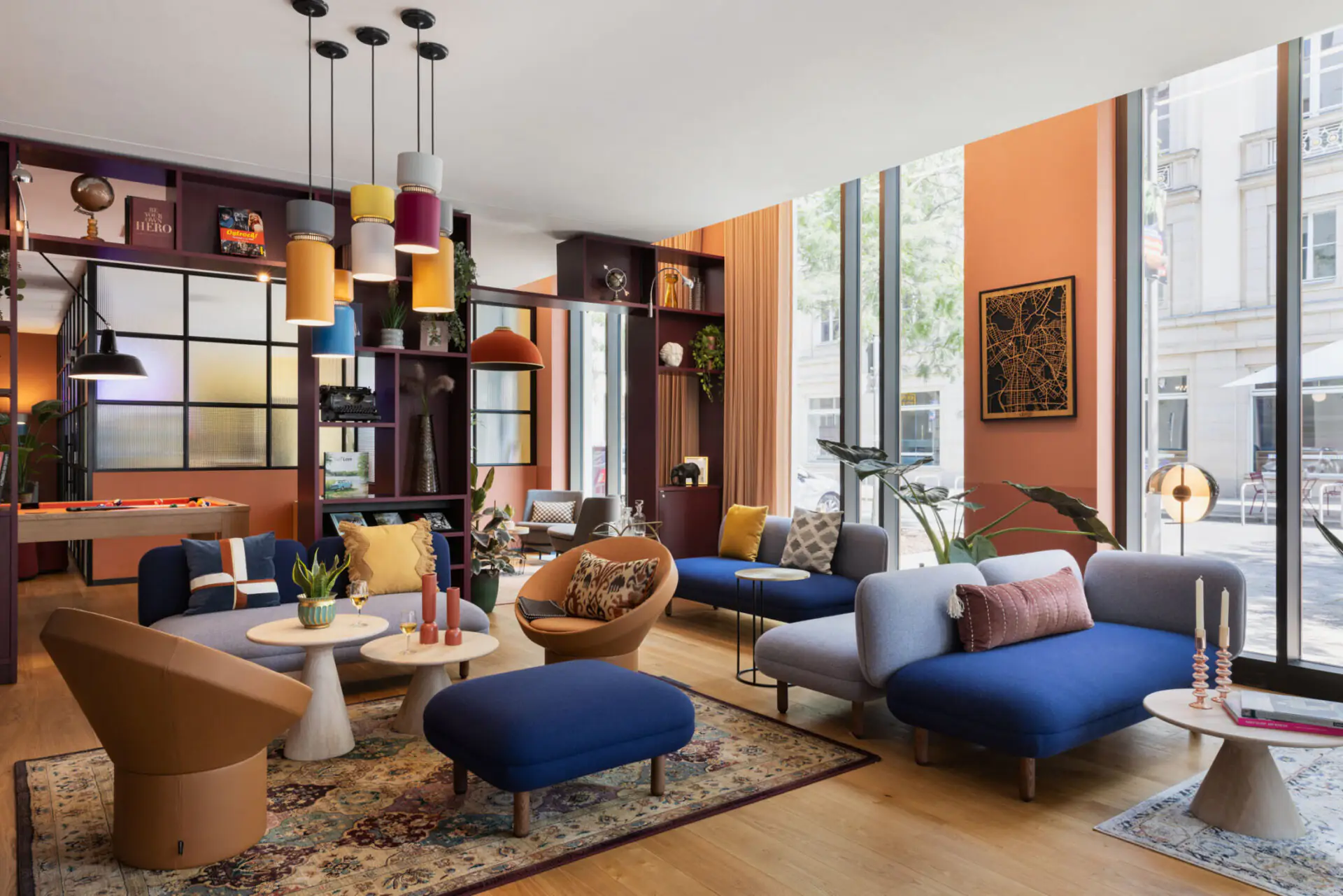 Spacious community lounge with colorful design, bookshelves and lighting accents – open and inviting.