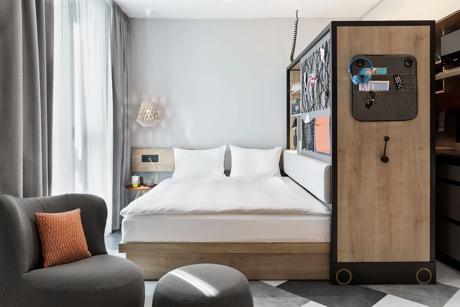 Bedroom with large window and semi-transparent curtain in a bright, modern interior design.