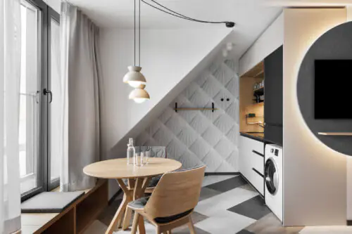 Heller Essplatz mit zwei Stühlen, Tisch und Fensterfront in einer modernen Studioecke.