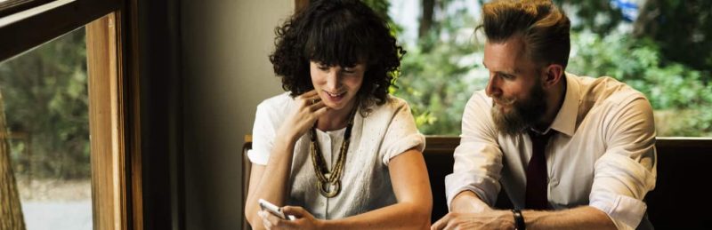 Two people looking at phone. Stay KooooK. Stay You.