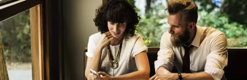 Two people looking at phone. Stay KooooK. Stay You.