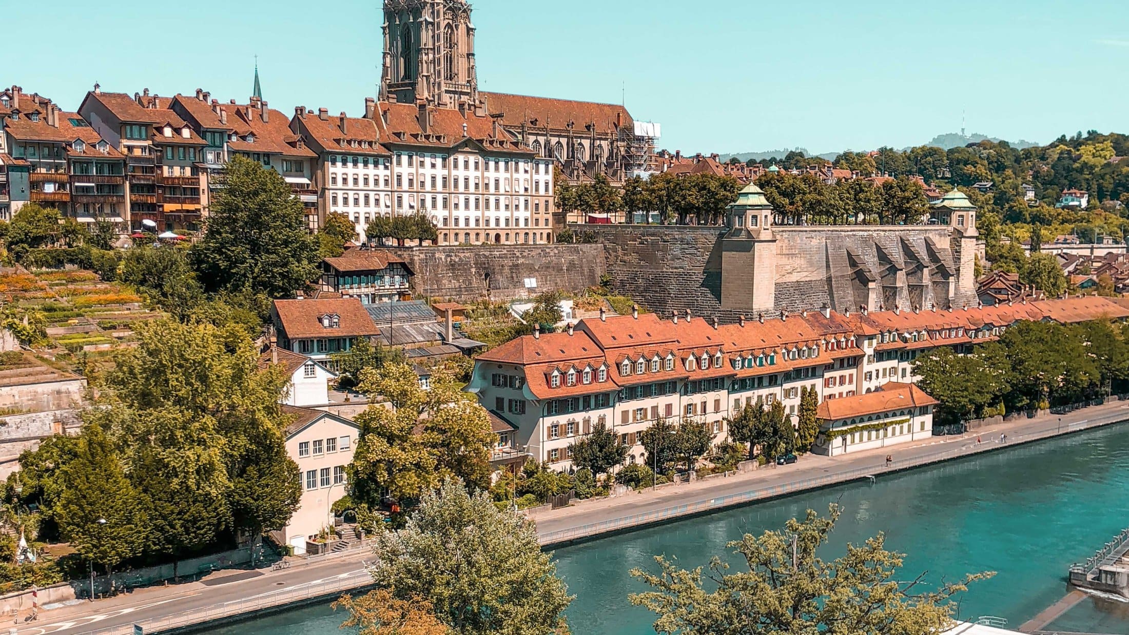 View over Bern’s old town with the Aare river, historic buildings and the cathedral on a sunny day.