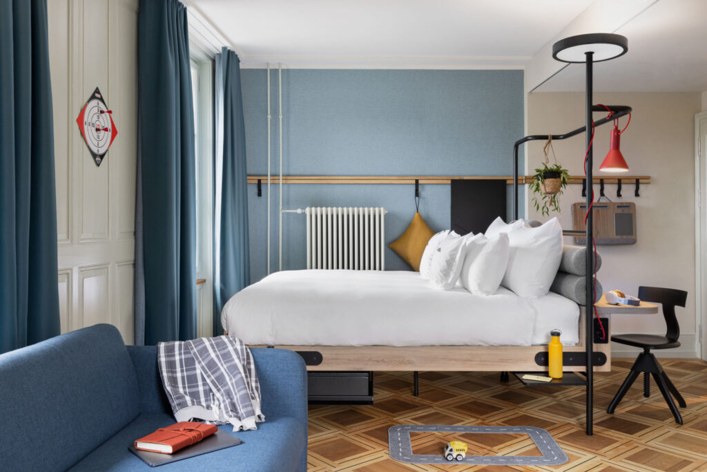 Family room in Bern city centre with a spacious bed, a cosy living area and a well-thought-out design for a relaxing stay together.