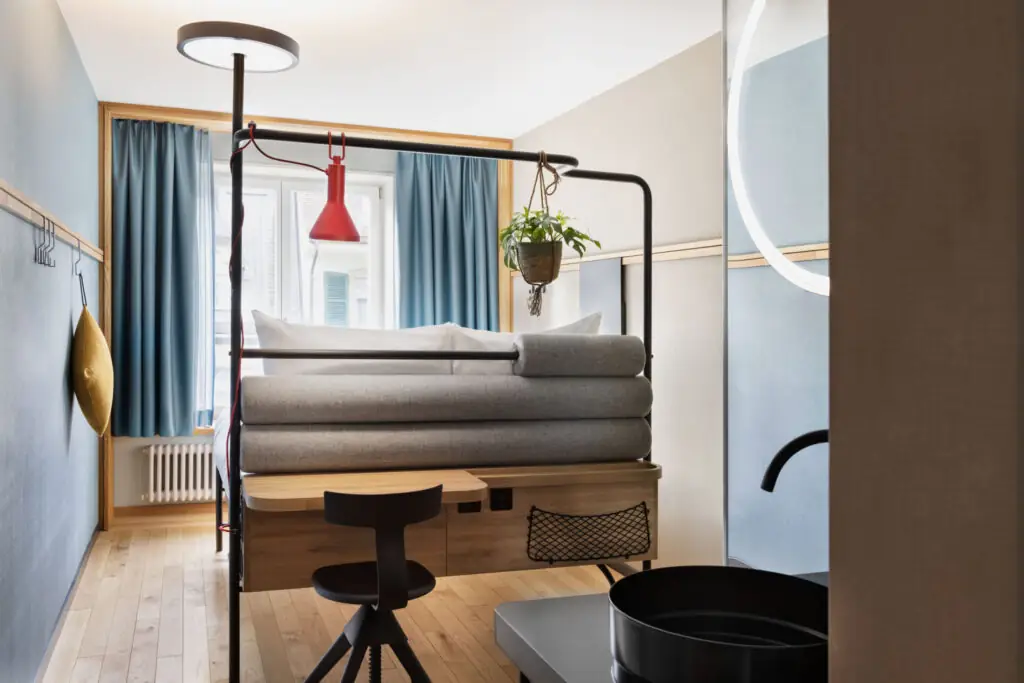 Coin lit et fenêtre avec coussins d'assise, vue sur la ville