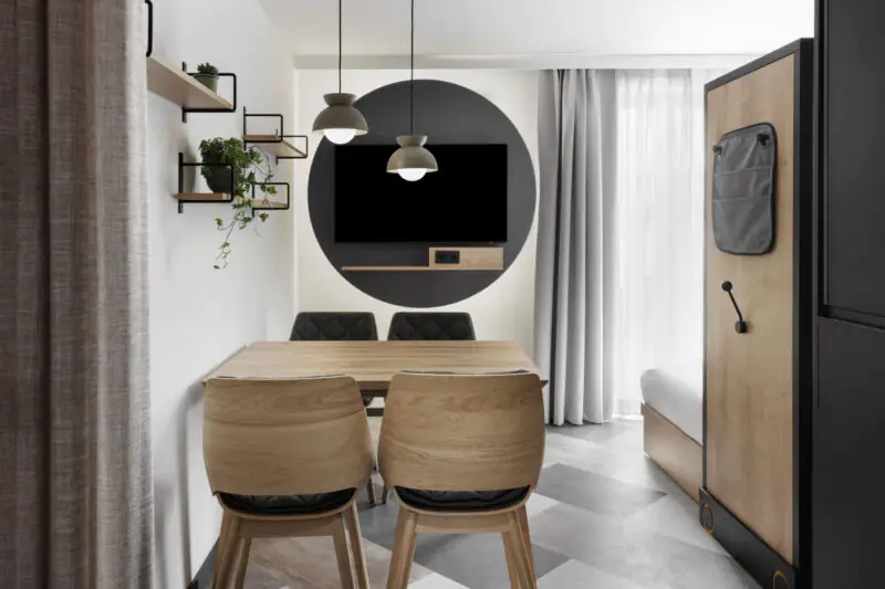 Open living and dining area in studio layout with seamless transition to kitchen and sleeping area.